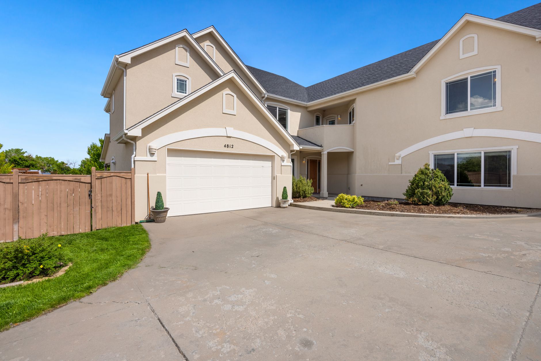 A suburban home exterior with a double garage door and landscaped front yard