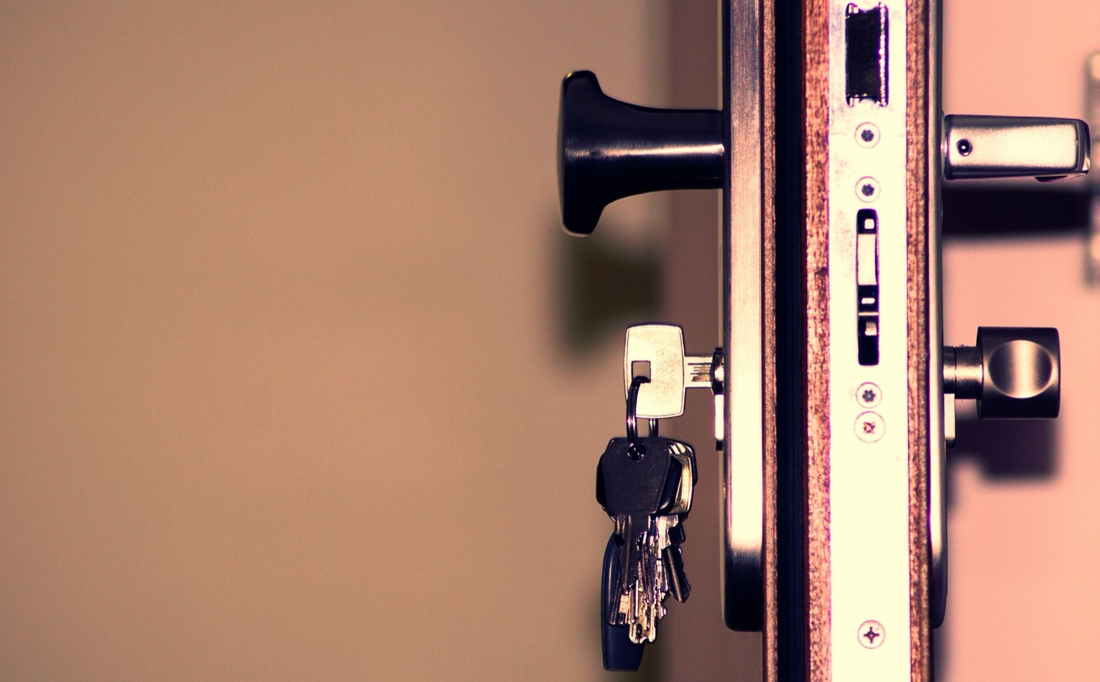 Close-up of a door lock cylinder and a set of keys