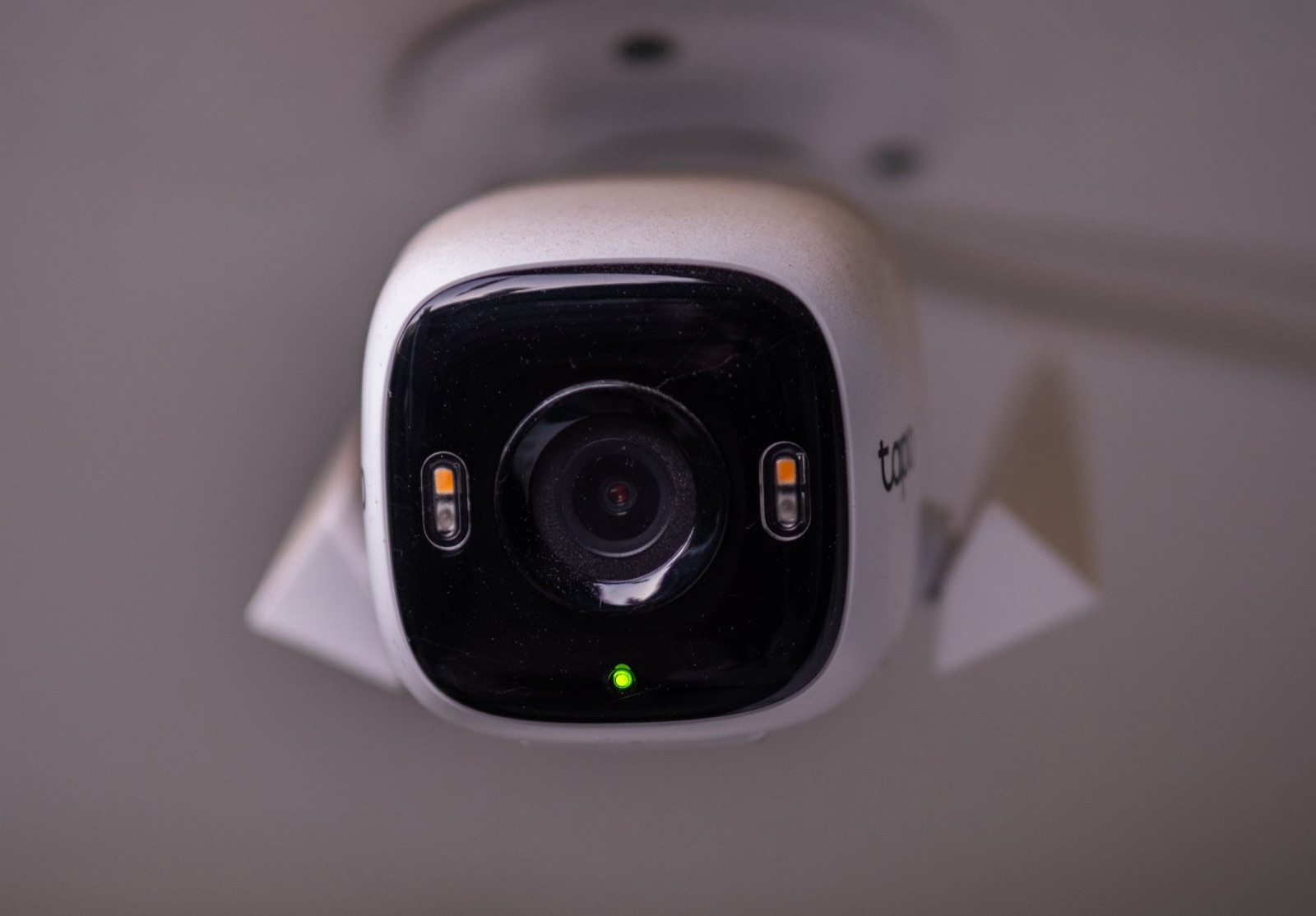 A white outdoor security camera mounted on a wall